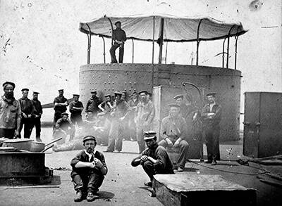 A black and white photo of civil war soldiers on the deck of the monitor