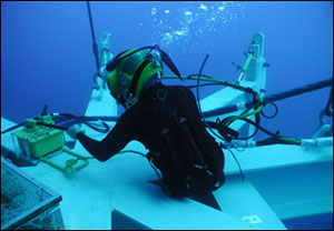 Navy Diver Petty Officer Steve Grier works to adjust one of the Spider's legs.