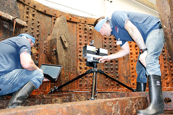 two researchers scan the recovered turret of the monitor