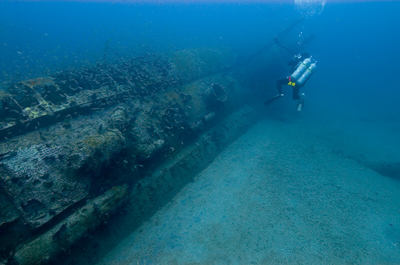 A diver inspects the shipwreck of a u-boat