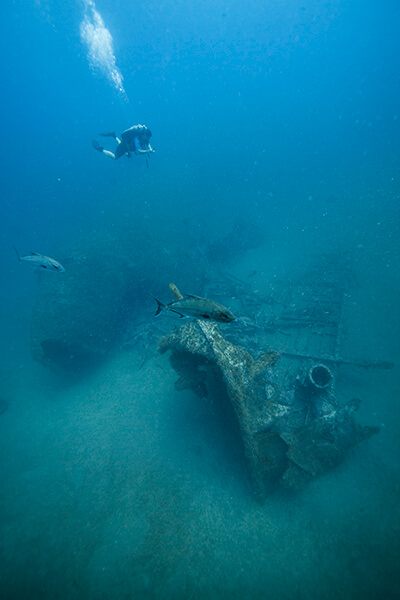 A scuba diver swims above a shipwreck